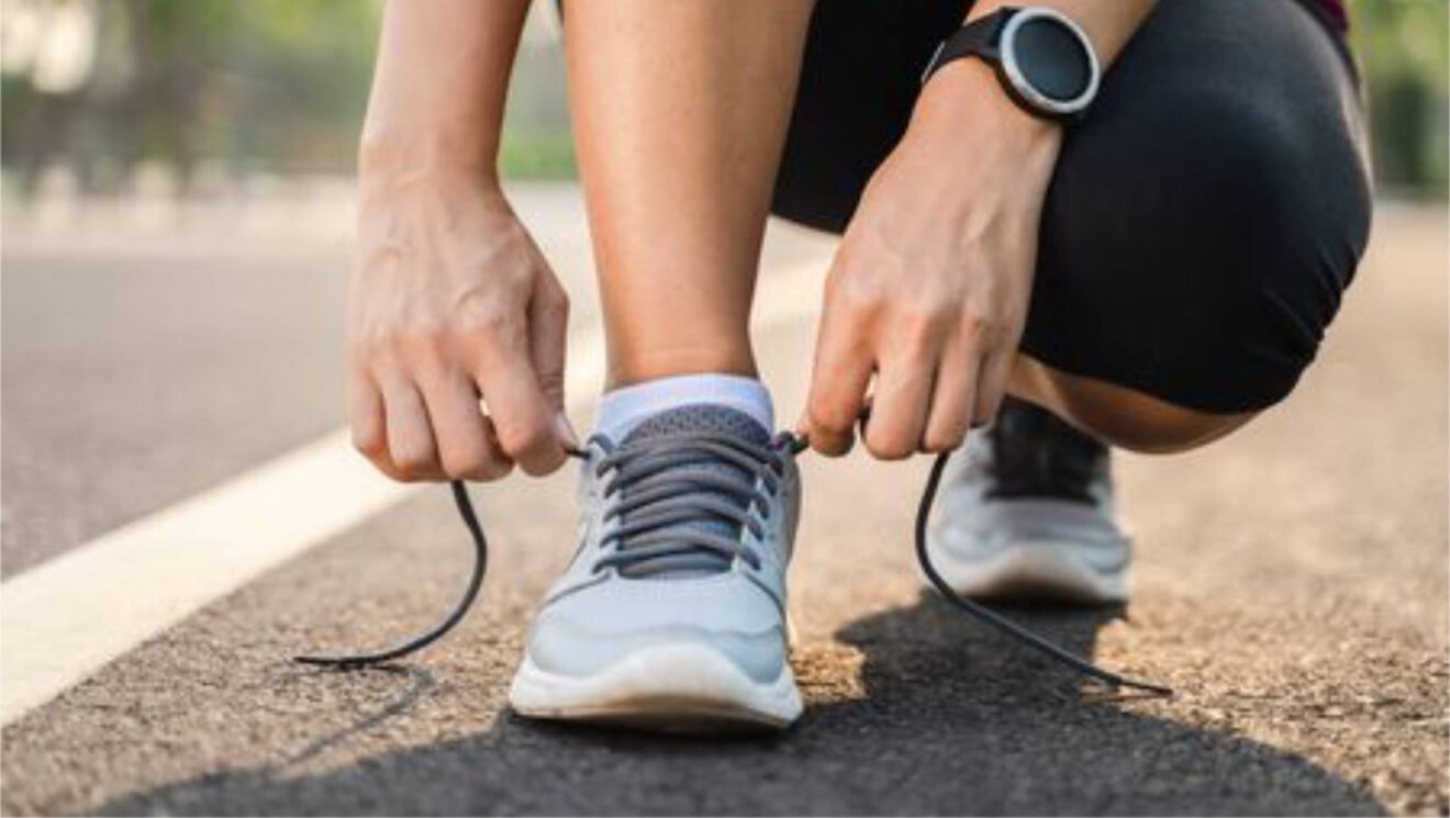 Läuferin schnürt vor dem Start ihre Laufschuhe